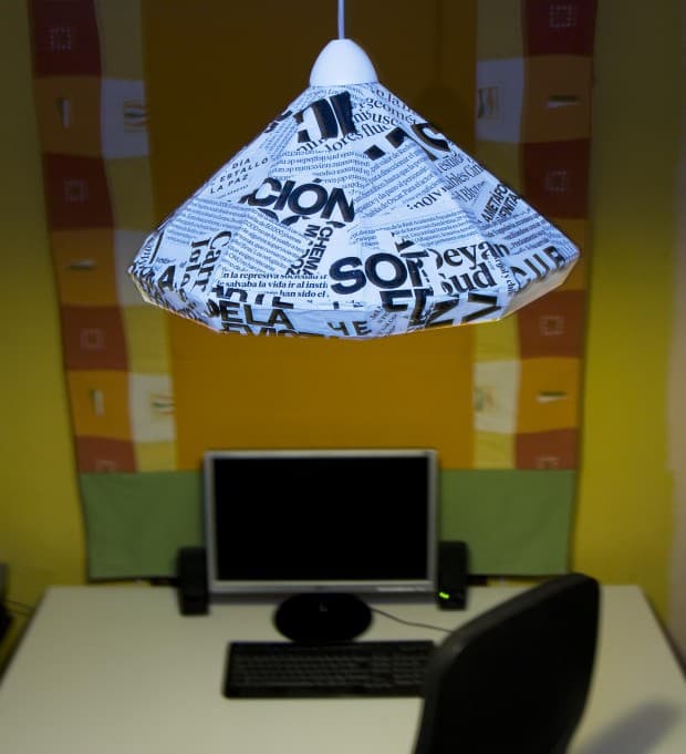 Lámpara de techo hecha con cartón y decorada con papel de periódico.