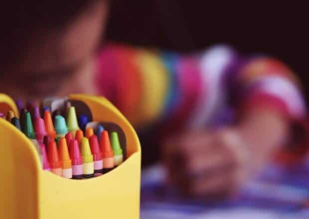 Un niño dibuja con pinturas de cera